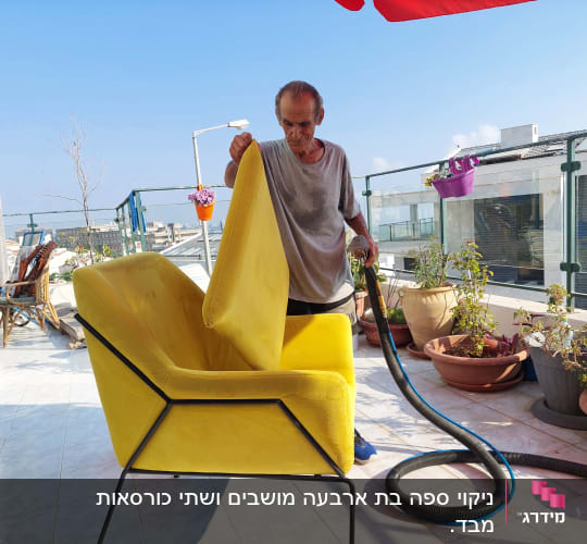 אדם מנקה ספה צהובה עם שואב אבק